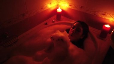Kabarcık banyo mum yakarak çekici genç kadın