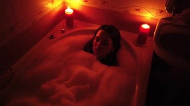 Kabarcık banyo mum yakarak çekici genç kadın