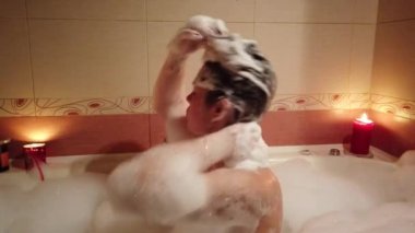 Banyo ve köpük onun banyoda çok üzerinde üfleme esmer genç kadın.