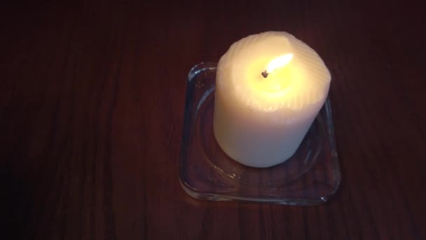 La naturaleza muerta - la vela que arde sobre la mesa castaña en la cafetería — Vídeos de Stock