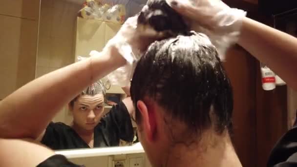 Chica morena para colorear su cabello en el baño en casa — Vídeo de stock