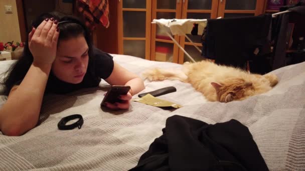 Una Ragazza Trova Divano Casa Gatto Rosso Usa Suo Smartphone — Video Stock