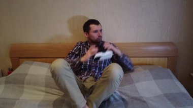 Adam yatakta sanal gerçeklik kulaklık görünüyor. Otel veya ev yatak odası