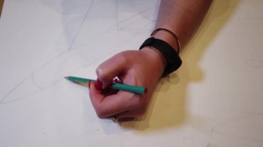 Bir sanat çizimi oluşturma sürecinde genç bir kadın sanatçının çekim yakın.