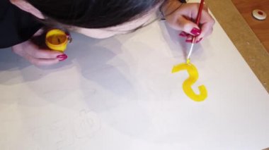 Bir sanat çizimi oluşturma sürecinde genç bir kadın sanatçının çekim yakın.