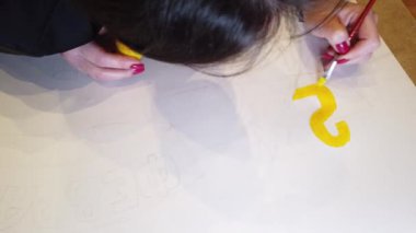 Bir sanat çizimi oluşturma sürecinde genç bir kadın sanatçının çekim yakın.
