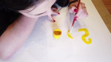 Bir sanat çizimi oluşturma sürecinde genç bir kadın sanatçının çekim yakın.