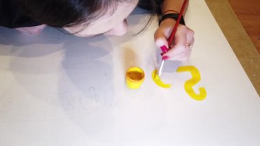 Bir sanat çizimi oluşturma sürecinde genç bir kadın sanatçının çekim yakın.