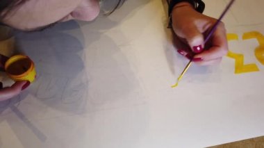 Güzel genç bayan meşgul boyama resim atölye parlak boya ve lekeli paleti kullanarak.