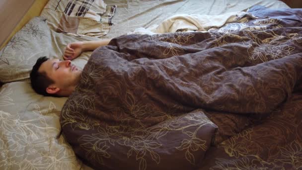 男は寝ていると 一人でベッドで目を覚ます 顔のクローズ アップ 朝の枕の上の頭と 代の大人の白人男性人のヘッド ショット — ストック動画