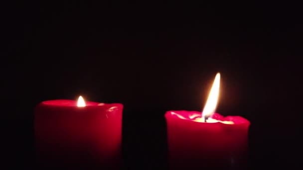Bougie rouge brûlante avec flamme scintillante sur fond sombre .