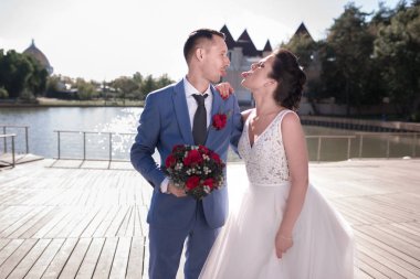 Evlilik çift niteliğine birbirlerine sarılıyor. Beyaz elbiseli güzel model kız. Takım elbiseli adam. Güzellik gelinle damat. Kadın ve erkek portre. Dantel örtü ile kadın. Kadın ve adam açık havada