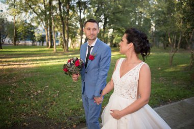 Evlilik çift niteliğine birbirlerine sarılıyor. Beyaz elbiseli güzel model kız. Takım elbiseli adam. Güzellik gelinle damat. Kadın ve erkek portre. Dantel örtü ile kadın. Kadın ve adam açık havada