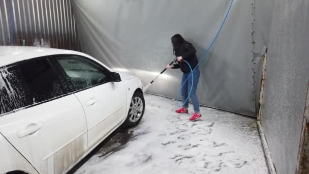 ロシア モスクワ 2019 ブルネットの女の子は スプレーツールを使用し ウォッシュボックスで泡によって車をカバー — ストック動画