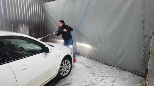 俄罗斯 莫斯科 2019年4月 褐发女郎使用喷雾工具 用泡沫覆盖洗车箱 — 图库视频影像