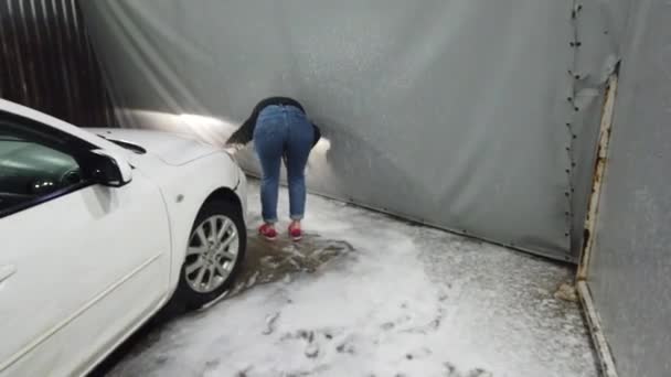 俄罗斯 莫斯科 2019年4月 褐发女郎使用喷雾工具 用泡沫覆盖洗车箱 — 图库视频影像