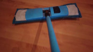 Paspaslı genç adam, Evdeki Yerleri Temizliyor. Adam odayı süpürüyor ve eve düzen ve temizlik getiriyor - Ev işi ve temizlik konsepti.