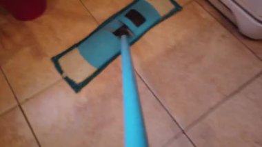 Paspaslı genç adam, Evdeki Yerleri Temizliyor. Adam odayı süpürüyor ve eve düzen ve temizlik getiriyor - Ev işi ve temizlik konsepti.