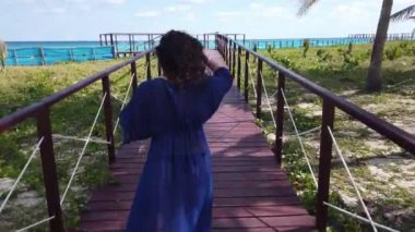 Beyaz tropikal plaj ve turkuaz okyanus yolunda Varadero ahşap bir köprü üzerinde Kız