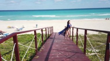 Beyaz tropikal plaj ve turkuaz okyanus yolunda Varadero ahşap bir köprü üzerinde Kız