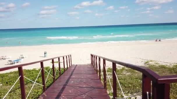 バラデロキューバ白い熱帯のビーチとターコイズブルーの海に向かう途中で、完璧なビーチブルーの海とバラデロの木製の橋 — ストック動画