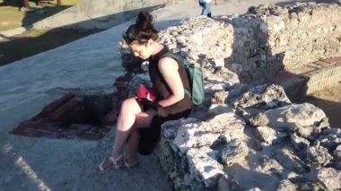 Rocky Shore Beach mavi gökyüzü yalnız oturan güzel kadın.
