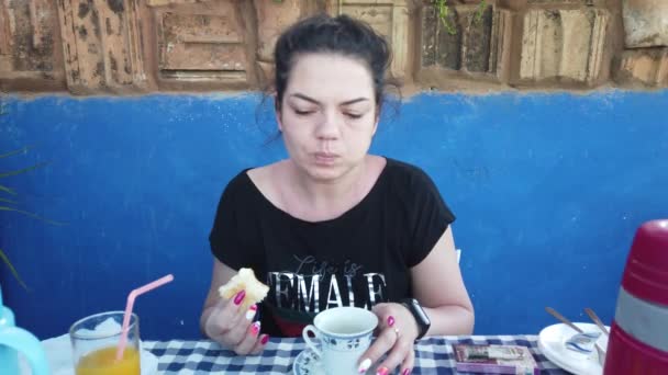 Hermosa joven fuma un cigarrillo al lado de una casa en la naturaleza. Chica desayunando en la terraza . — Vídeos de Stock