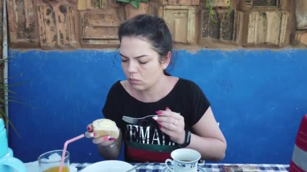 美しい若い女性は自然の家の隣でタバコを吸う ベランダで朝食を食べる女の子 — ストック動画