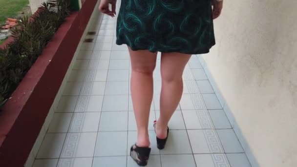 ゲストホテルのバックビューで廊下を歩くハイヒールの靴の女性の足 リゾートホテルの屋外バルコニーで長い廊下を歩く女性の足 スローモーション — ストック動画