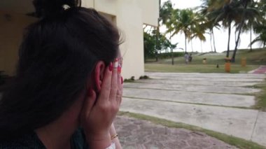 Tatil köyünde dinlenmiş bir kız. Otelde palmiye ağaçlarında dinlenin. Kız oturma ve tvening sessiz dinlenme.