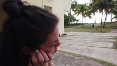 Tatil köyünde dinlenmiş bir kız. Otelde palmiye ağaçlarında dinlenin. Kız oturma ve tvening sessiz dinlenme.