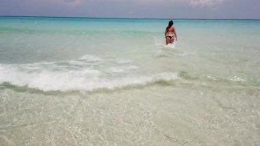 Varadero, Küba sahilinde okyanusta yüzen, bikini içinde yüzen ve suda yüzen güzel genç kadın. Kadın plajda yaz tatili zevk.