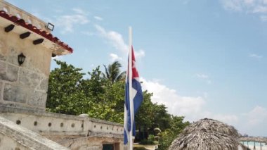 Sahilde Küba bayrağı, okyanusun arka planında rüzgarda uçuyor. Küba, Varadero.