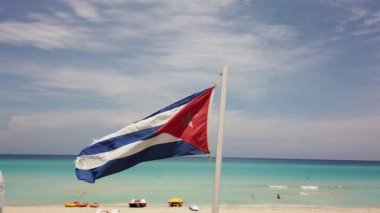 Sahilde Küba bayrağı, okyanusun arka planında rüzgarda uçuyor. Küba, Varadero.