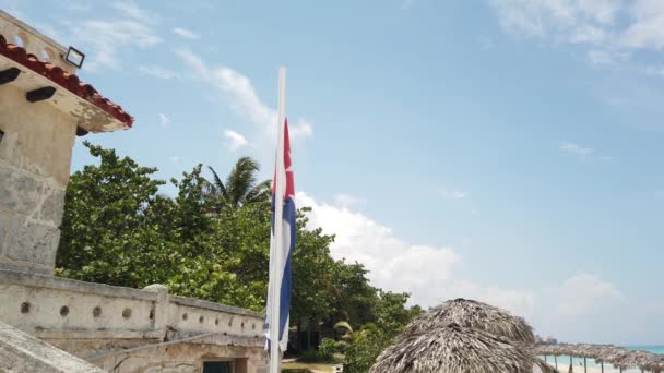 海の背景に風の中を飛んで ビーチでキューバの旗 キューバ バラデロ — ストック動画