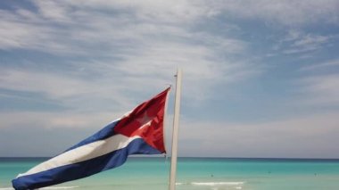 Sahilde Küba bayrağı, okyanusun arka planında rüzgarda uçuyor. Küba, Varadero.