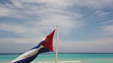 Sahilde Küba bayrağı, okyanusun arka planında rüzgarda uçuyor. Küba, Varadero.
