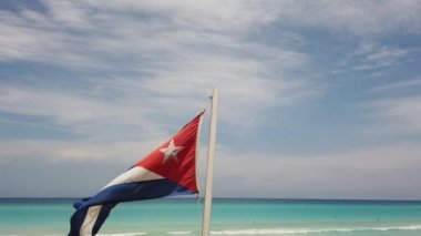 Sahilde Küba bayrağı, okyanusun arka planında rüzgarda uçuyor. Küba, Varadero.