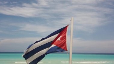 Sahilde Küba bayrağı, okyanusun arka planında rüzgarda uçuyor. Küba, Varadero.