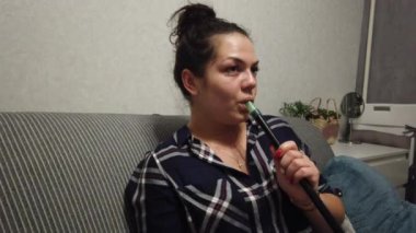 Genç güzel kız evde bir nargile içiyor