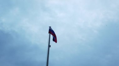 Bayrak direğinde ki Rus bayrağı bulutlar ile mavi bir gökyüzüne karşı rüzgarda sallayarak