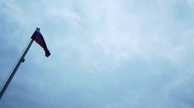 Bayrak direğinde ki Rus bayrağı bulutlar ile mavi bir gökyüzüne karşı rüzgarda sallayarak