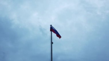 Bayrak direğinde ki Rus bayrağı bulutlar ile mavi bir gökyüzüne karşı rüzgarda sallayarak