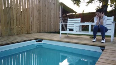 Kız yüzme havuzunda sigara içiyor. Havuz başında akşam dinlenen kız