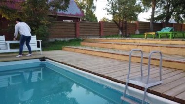 Kız yüzme havuzunda sigara içiyor. Havuz başında akşam dinlenen kız