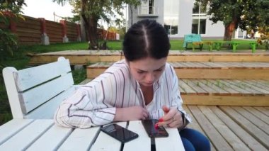 Cep telefonu kadın kullanımı ve bahçesinde evde bankta oturup