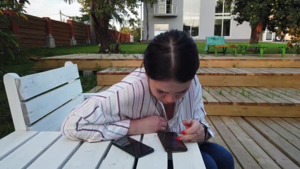Женщина Использовать Мобильный Телефон Сидеть Скамейке Дворе Дома — стоковое видео