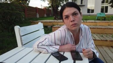 Cep telefonu kadın kullanımı ve bahçesinde evde bankta oturup