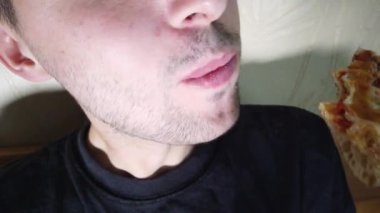 Adam fast food ısırarak pizza dilim aşırı yakın yiyor