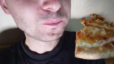 Adam fast food ısırarak pizza dilim aşırı yakın yiyor